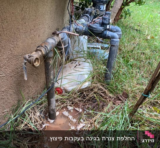 צינור מים דולף עם שלולית קטנה על הקרקע